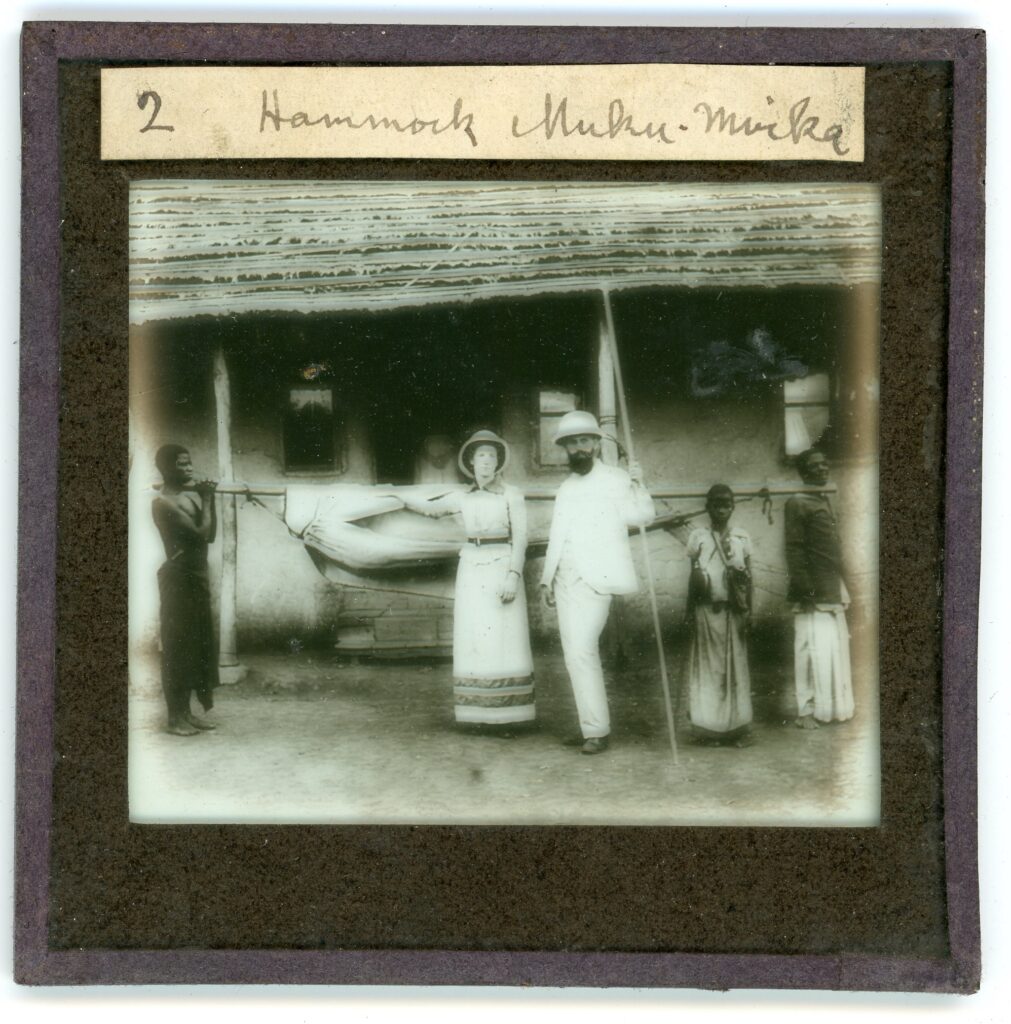 Group of people carrying hammock outside building