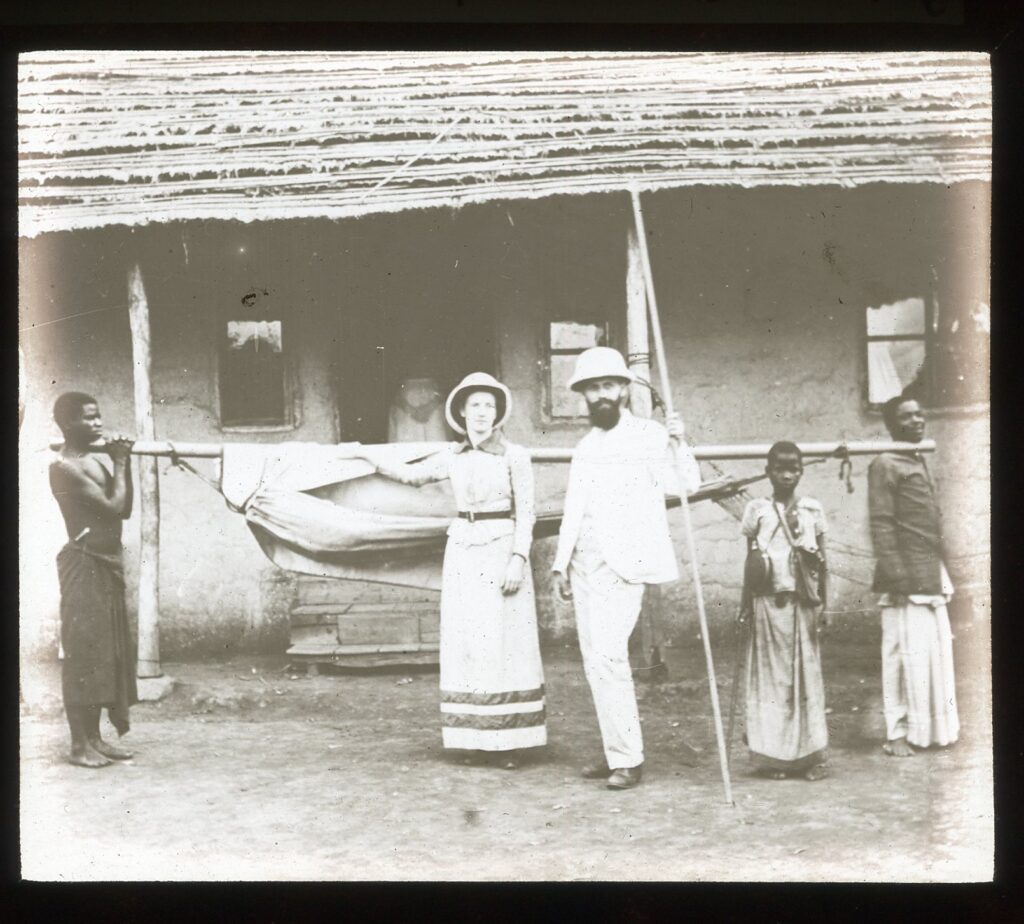 Group of people carrying hammock outside building