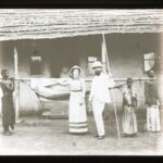 Group of people carrying hammock outside building