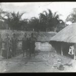 A local chief with his wives in a village courtyard