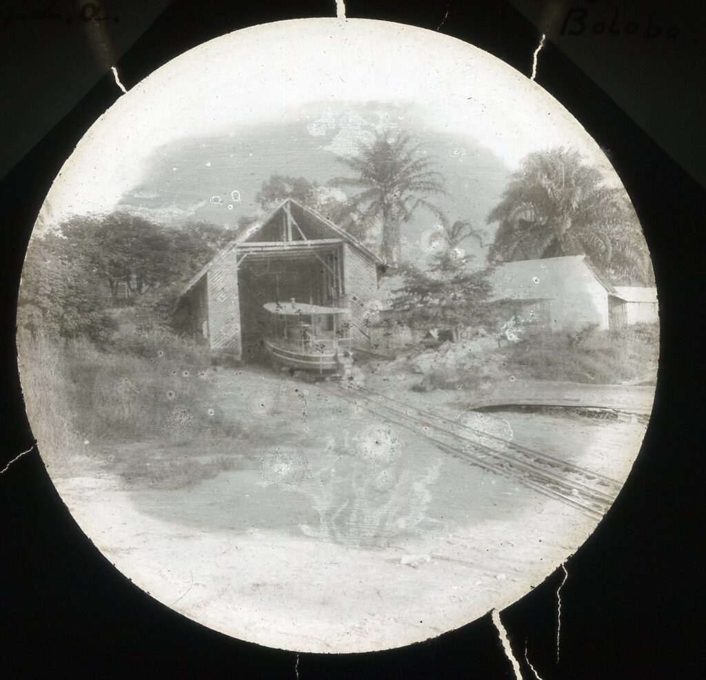 A small dockyard boathouse with a rail leading to the water