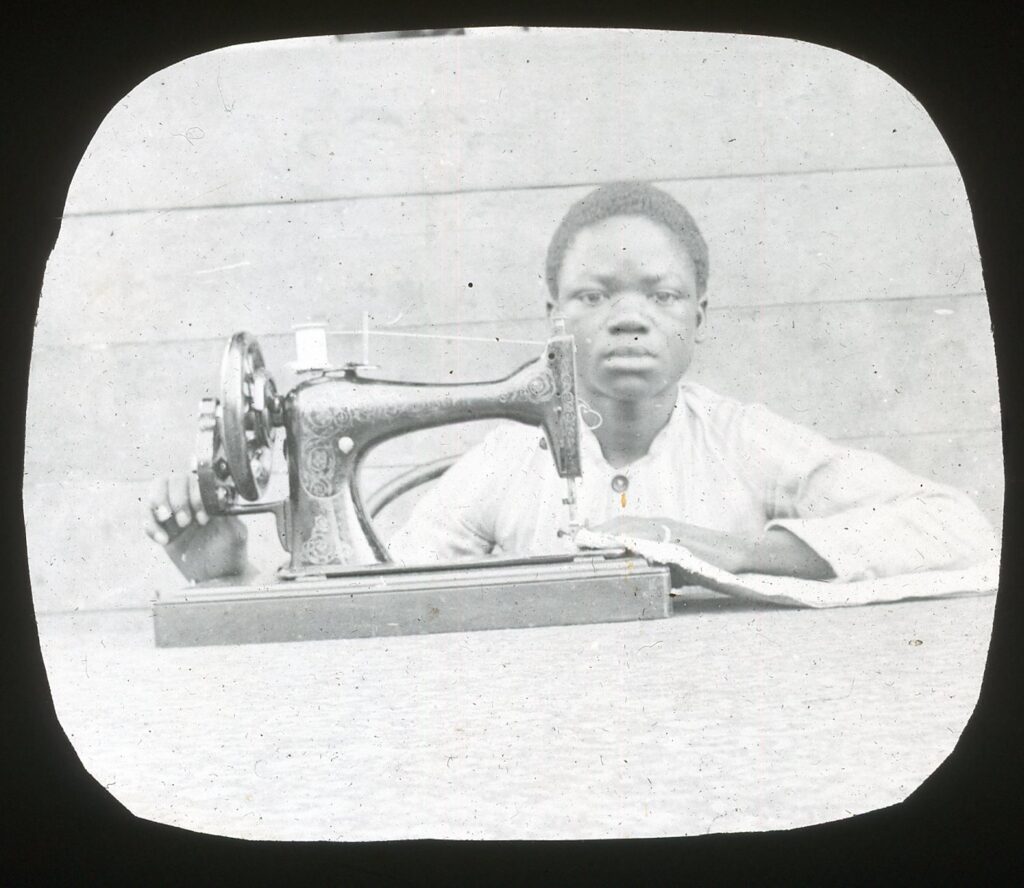 A local child operating a Singer's sewing machine