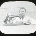 A local child operating a Singer's sewing machine