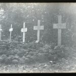 View of a village graveyard with graves marked by stone piles and wooden crosses