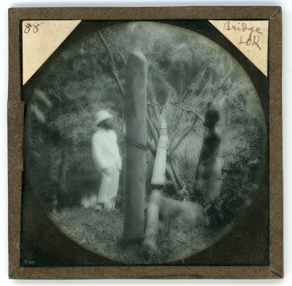 A missionary and a local by a simple wooden plank bridge