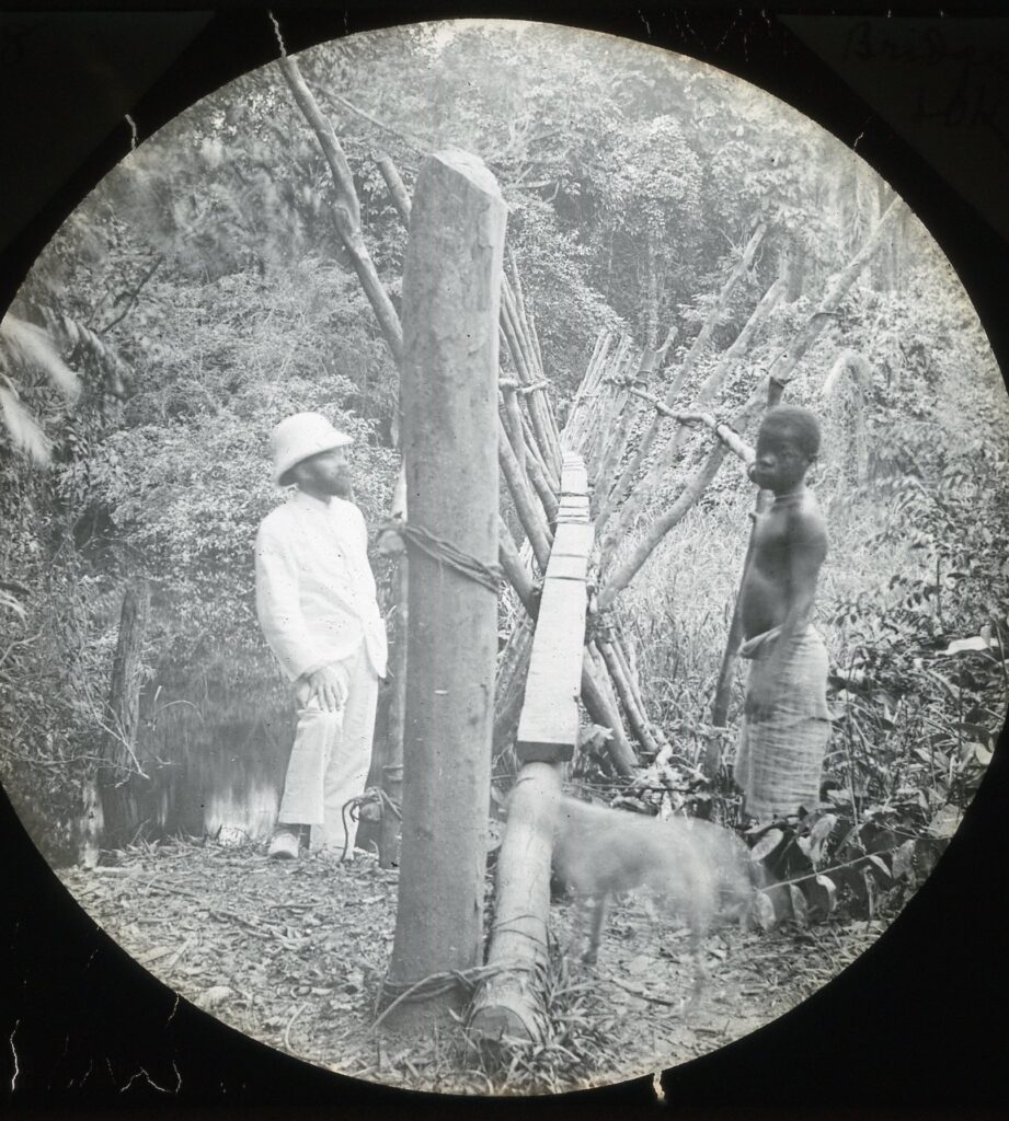 A missionary and a local by a simple wooden plank bridge