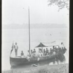 A large rowing boat on the banks of an wide river