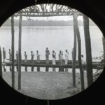 A large canoe on the bank of a wide river