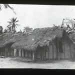 A simple wooden, straw-roofed mission house