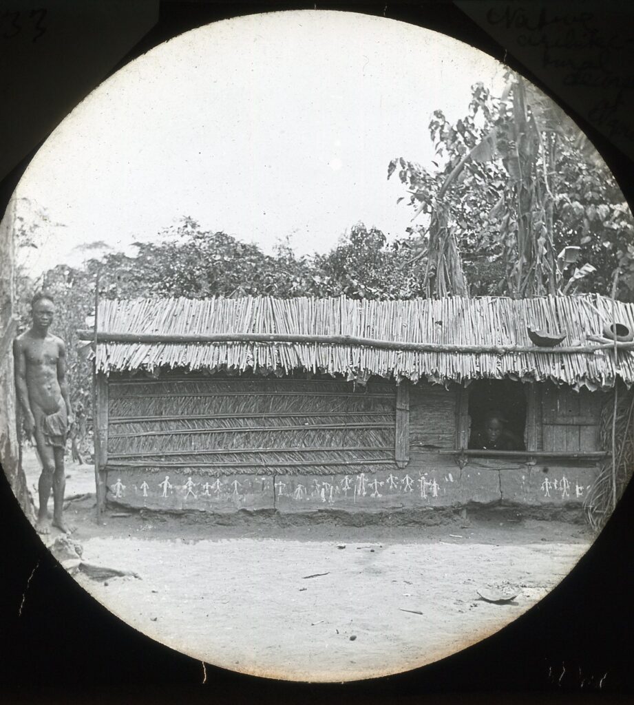 A small hut wall demonstrating local architectural decorative practices (including painting simple figures)