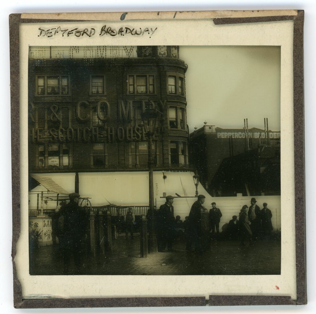 Slide showing a square with Edwardian working-class figures in front of a large department store with sign reading 'the Scotch House'
