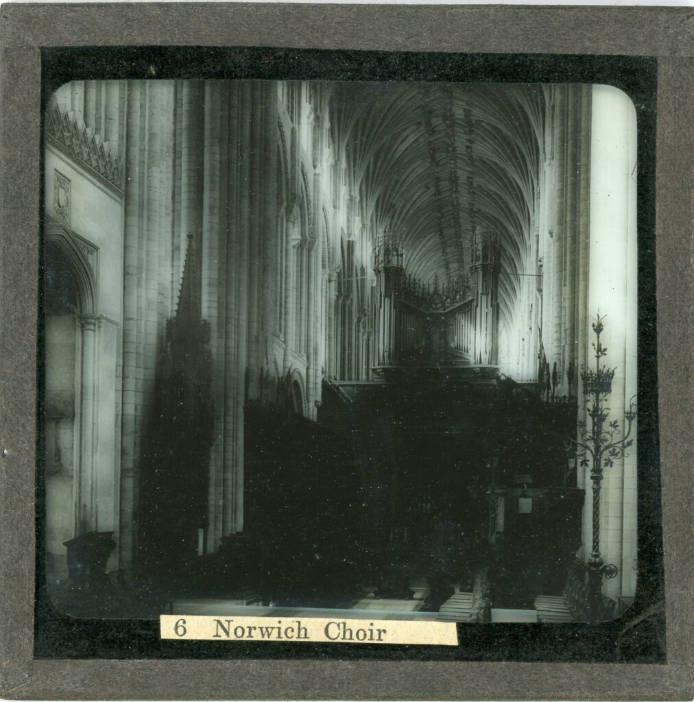 Slide showing the interior of Norwich cathedral showing the choir area with conducting pulpit, organ and ribbed vaulting above