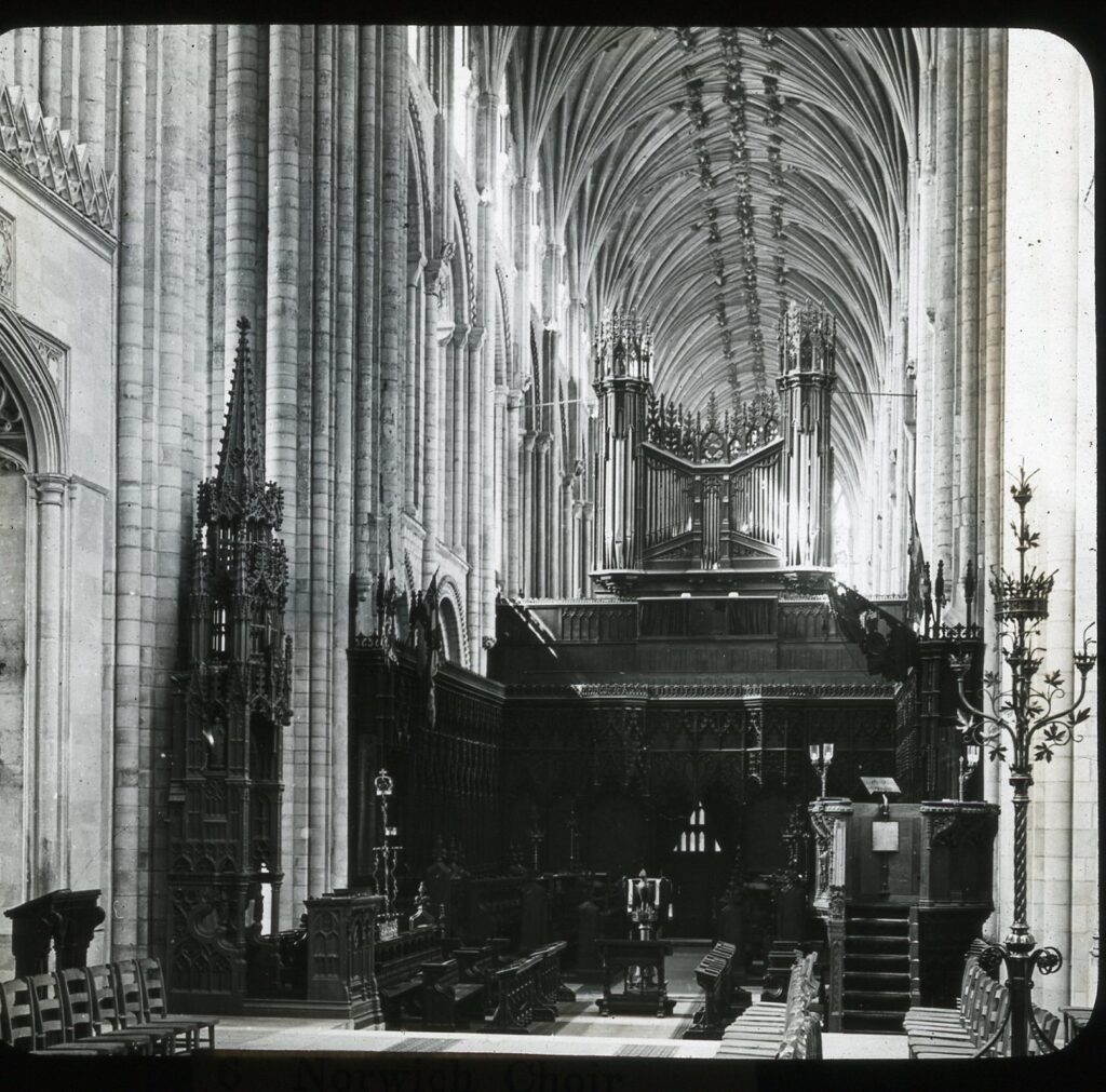 Slide showing the interior of Norwich cathedral showing the choir area with conducting pulpit, organ and ribbed vaulting above