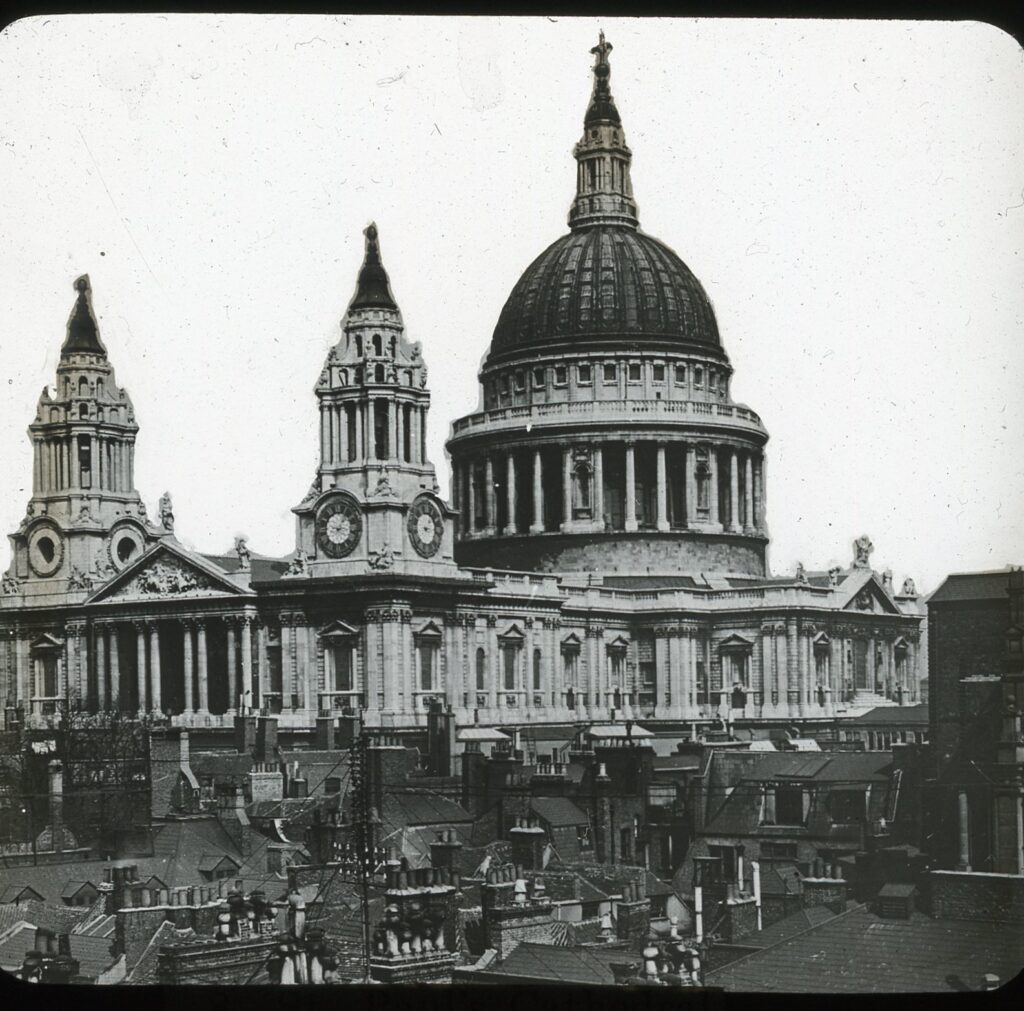 Slide showing the baroque St Paul's cathedral as viewed over tiled rooftops and chimney stacks