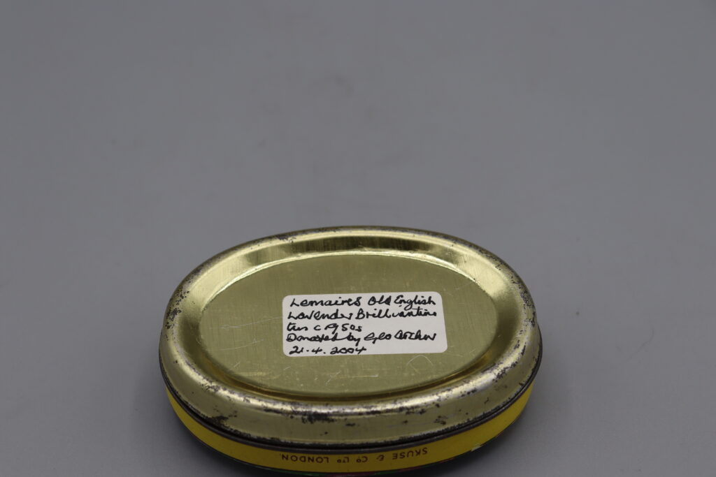 Oval metal tin, view of base with artifact label