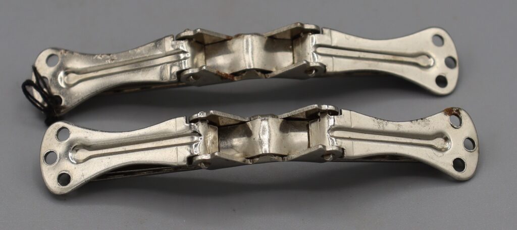 Two metal collar clips, back view, clips closed