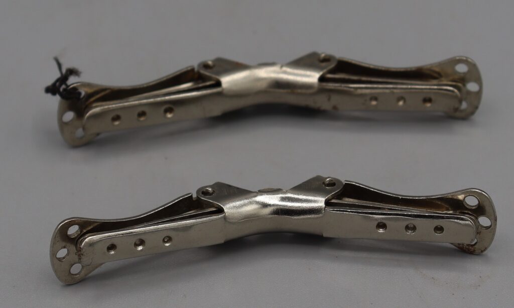Two metal collar clips, side view, clips closed
