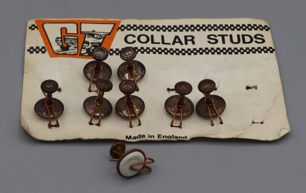 Eight metal collar studs, one stud detached from card