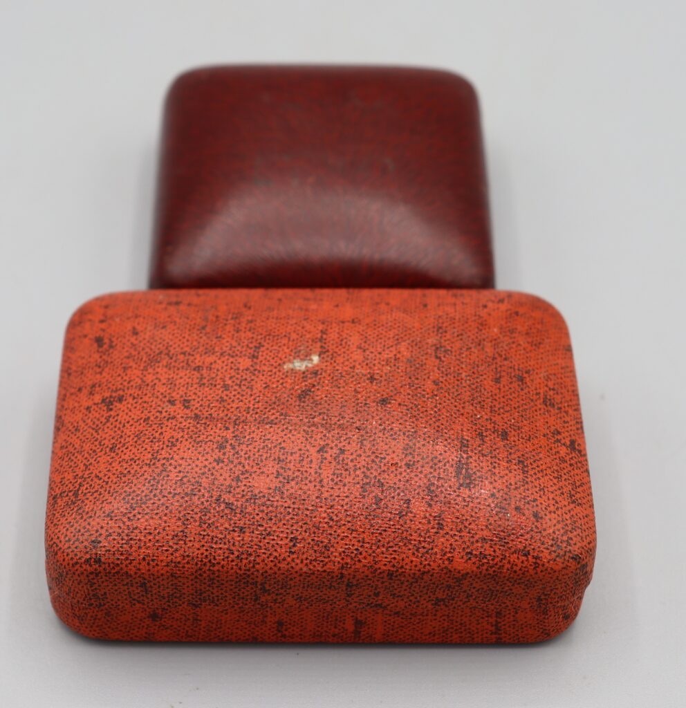 Two jeweller's boxes, one maroon, one tan coloured