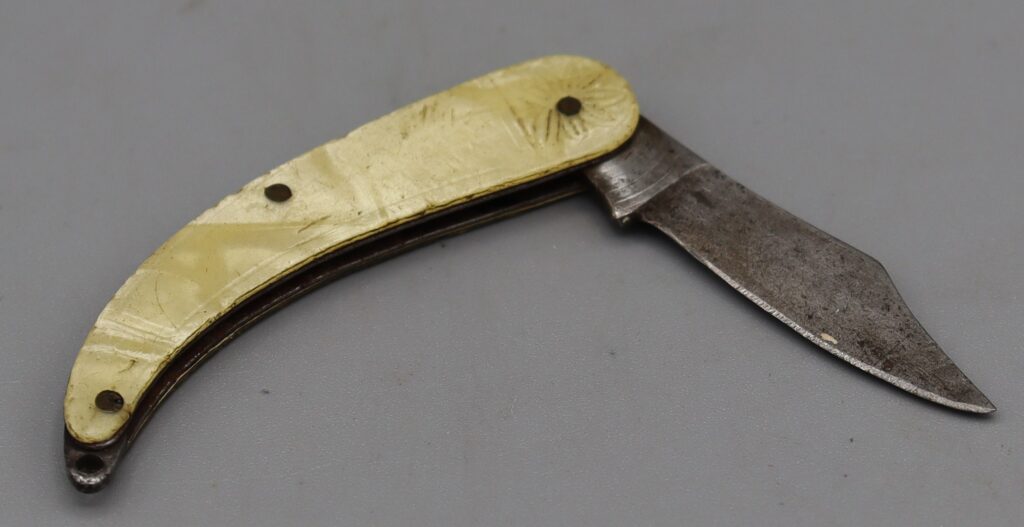 Penknife with single scimitar shaped blade. Shown in open position