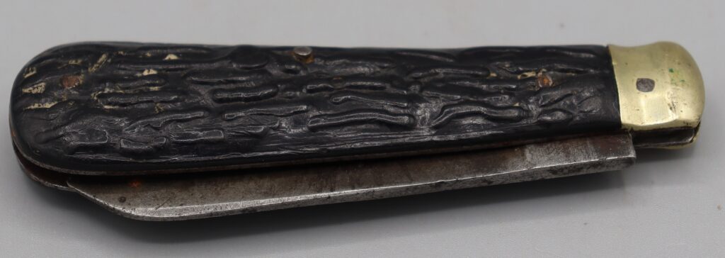 Brown handled penknife shown in closed position, left side up