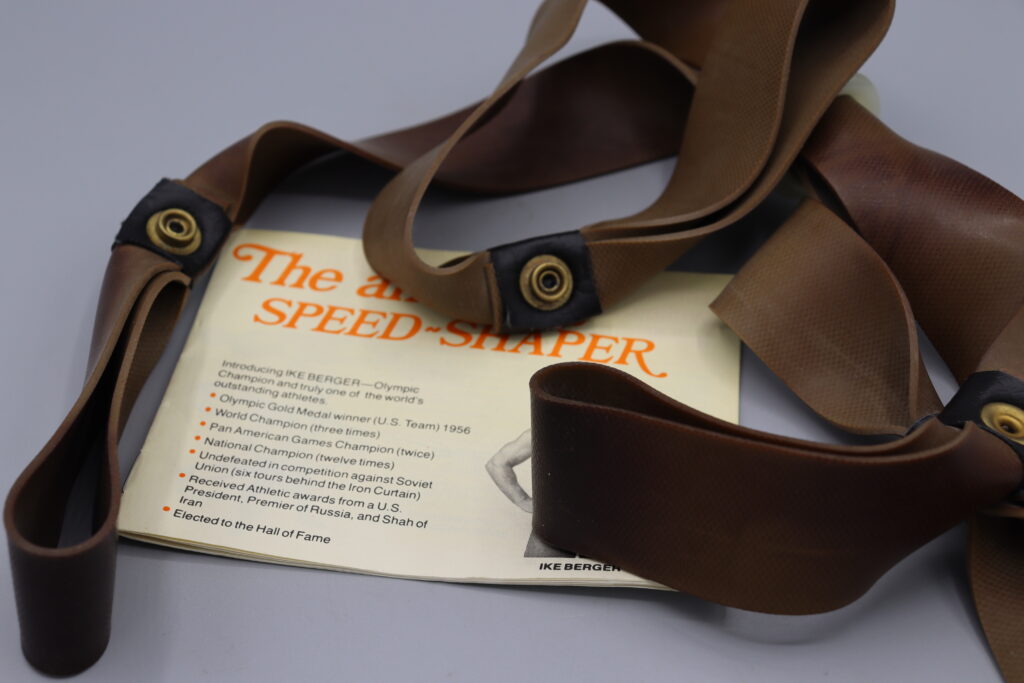 Exercise aid consisting of two rubber straps joined at the centre. Shown with instruction booklet