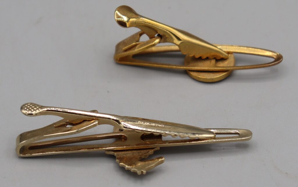 Two tie clips, gold tone metal, shown on reverse side