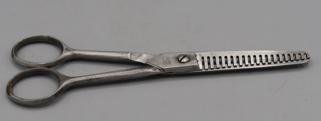Pair of hairdressers thinning scissors, shown in closed position