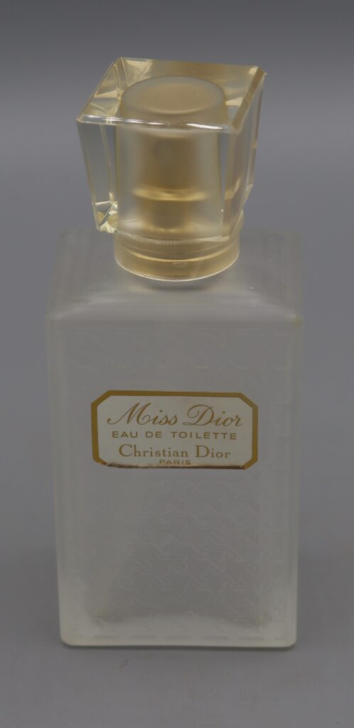 a glass bottle with Miss Dior toilet water