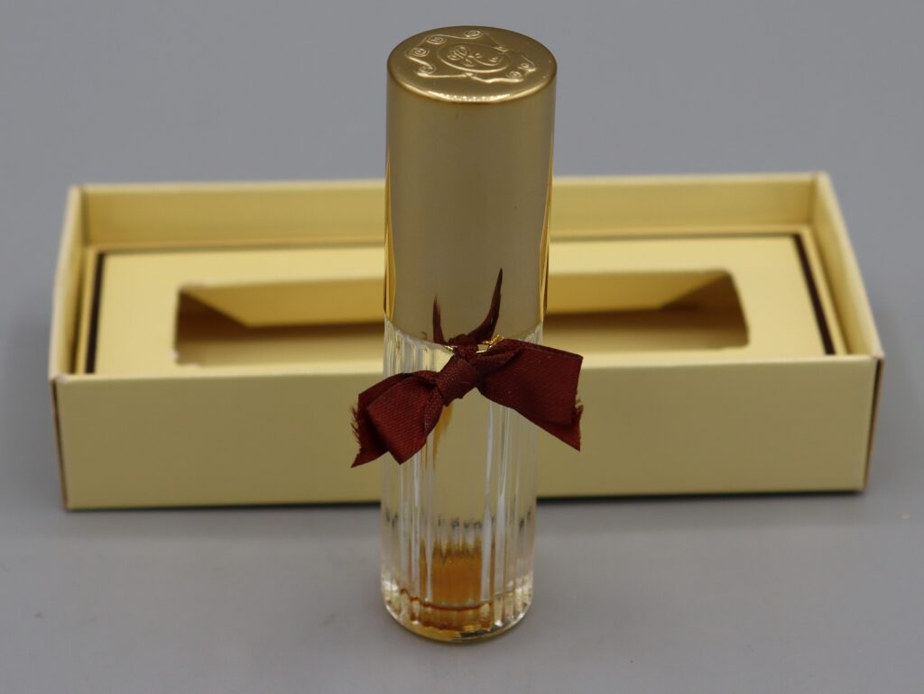 a glass bottle with a bow containing perfume