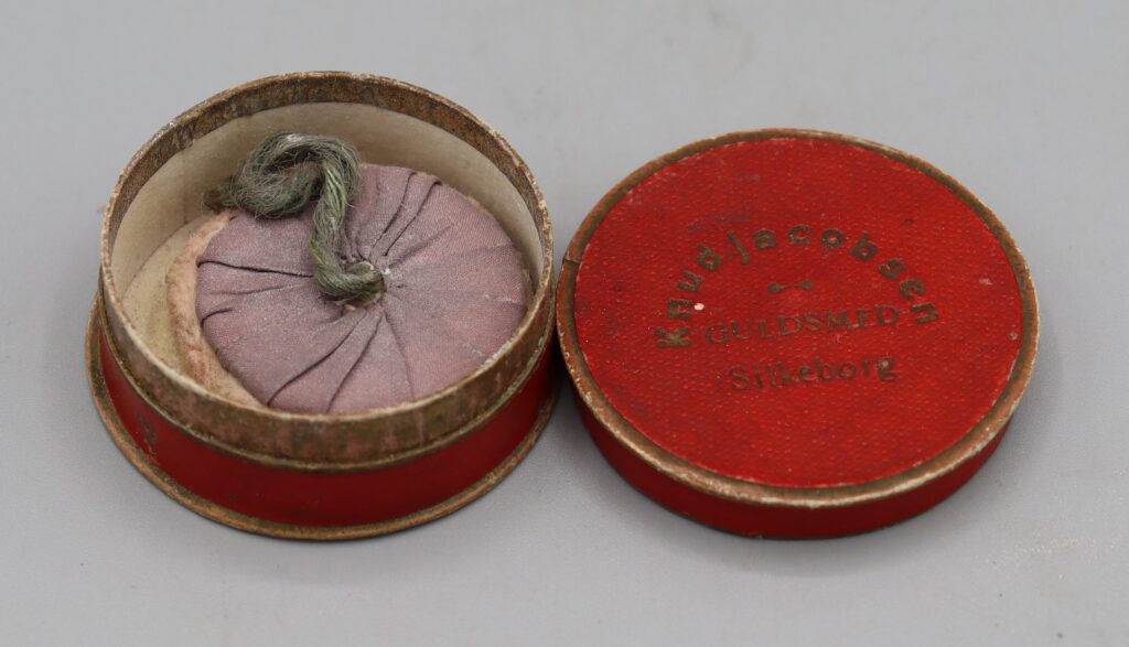 mauve powder puff inside the red jewellery box