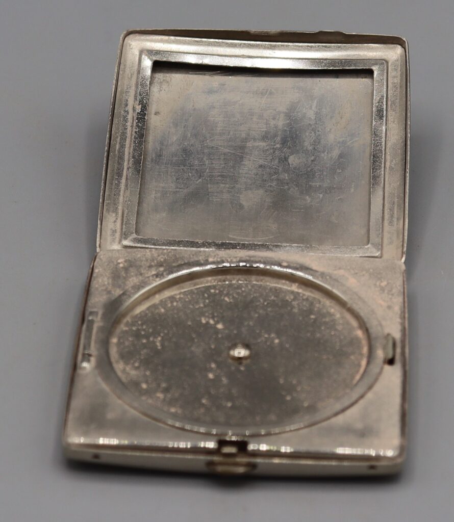 silver-coloured powder compact