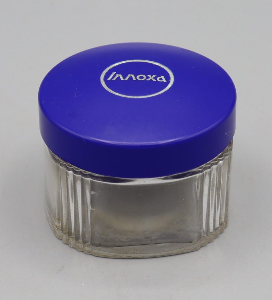 glass bottle with blue plastic top, labelled Innoxa
